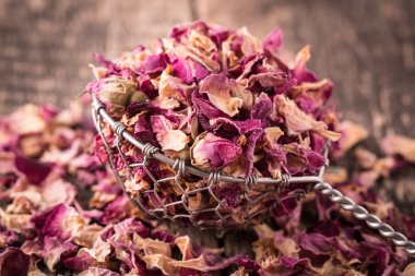 Gül yaprakları ve eski ahşap masa kaşık çiçek kurutulmuş