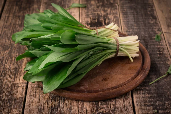 Colheita fresca de ramson primavera ou erva de alho-poró selvagem deixa cacho no fundo da mesa de madeira vintage — Fotografia de Stock