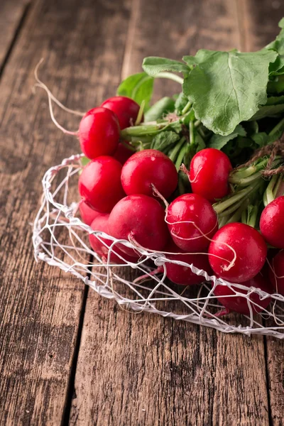 Fresh rustic harvest of radishes healthy vegetables in vintage basket background — Stock Photo, Image