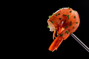 siyah arka plan üzerine soğan ile sıcak taze karides