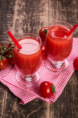 Domates suyu ve ahşap arka plan üzerinde taze domates