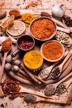 Ahşap masada baharatlar ve otlar.