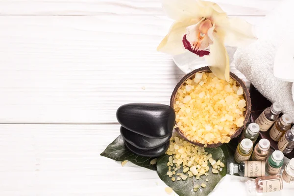 spa concept with stones, flowers , essential oils and mineral salt  on wooden table