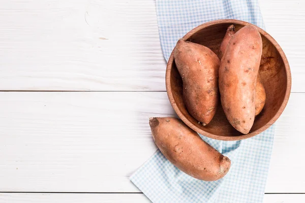 Raw sweet potatoes on wooden background closeup — Stock Photo, Image
