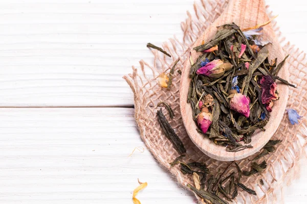 Té verde, hojas secas, sobre fondo de madera — Foto de Stock