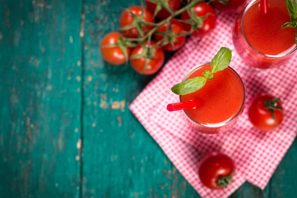 Zumo de tomate y tomates frescos en un fondo de madera —  Fotos de Stock