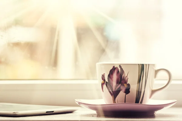 Hot drink cup beside window whith spring flower — Stock Photo, Image