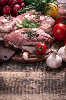 Taze kasap et ürün yelpazesine ahşap masa üzerinde taze biberiye ile süslenmiş kesmek