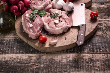 Taze kasap et ürün yelpazesine ahşap masa üzerinde taze biberiye ile süslenmiş kesmek