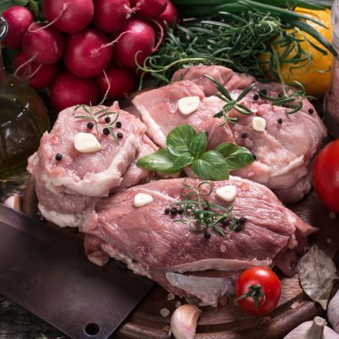 Taze kasap et ürün yelpazesine ahşap masa üzerinde taze biberiye ile süslenmiş kesmek