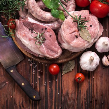 Taze kasap et ürün yelpazesine ahşap masa üzerinde taze biberiye ile süslenmiş kesmek