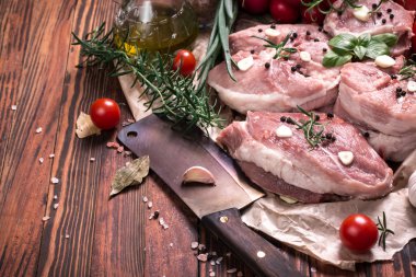 Taze kasap et ürün yelpazesine ahşap masa üzerinde taze biberiye ile süslenmiş kesmek