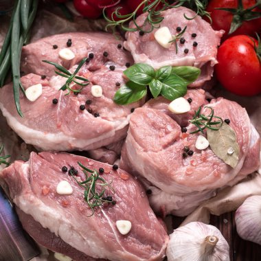 Taze kasap et ürün yelpazesine ahşap masa üzerinde taze biberiye ile süslenmiş kesmek