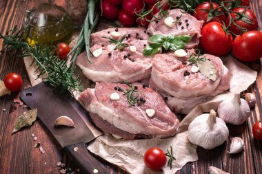 Taze kasap et ürün yelpazesine ahşap masa üzerinde taze biberiye ile süslenmiş kesmek