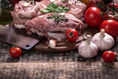 Taze kasap et ürün yelpazesine ahşap masa üzerinde taze biberiye ile süslenmiş kesmek