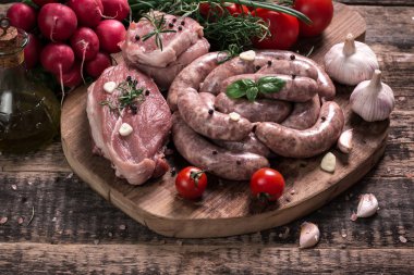 Taze kasap et ürün yelpazesine ahşap masa üzerinde taze biberiye ile süslenmiş kesmek