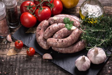 Taze kasap et ürün yelpazesine ahşap masa üzerinde taze biberiye ile süslenmiş kesmek