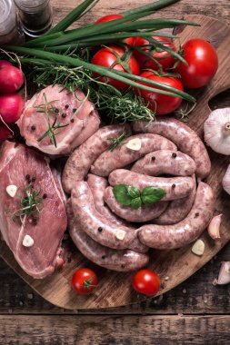 Taze kasap et ürün yelpazesine ahşap masa üzerinde taze biberiye ile süslenmiş kesmek