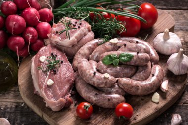 Taze kasap et ürün yelpazesine ahşap masa üzerinde taze biberiye ile süslenmiş kesmek