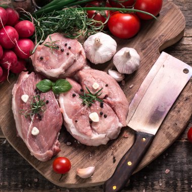 Taze kasap et ürün yelpazesine ahşap masa üzerinde taze biberiye ile süslenmiş kesmek
