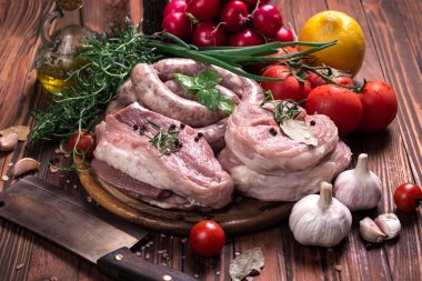 Taze kasap et ürün yelpazesine ahşap masa üzerinde taze biberiye ile süslenmiş kesmek