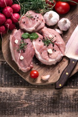 Taze kasap et ürün yelpazesine ahşap masa üzerinde taze biberiye ile süslenmiş kesmek
