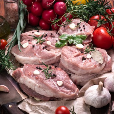 Taze kasap et ürün yelpazesine ahşap masa üzerinde taze biberiye ile süslenmiş kesmek