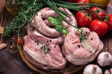 Taze kasap et ürün yelpazesine ahşap masa üzerinde taze biberiye ile süslenmiş kesmek