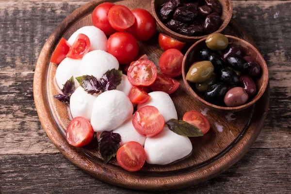 Mozzarella bollar med tomater och basilika på skiffer ombord — Stockfoto