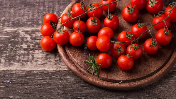 Cherry rajčata na dřevěném pozadí — Stock fotografie