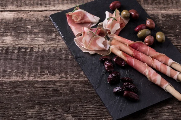 Felii curbate de Prosciutto delicios cu condimente din bucătăria italiană — Fotografie, imagine de stoc