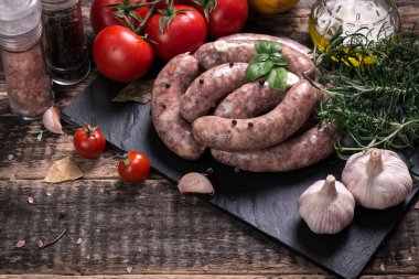 Taze kasap et ürün yelpazesine ahşap masa üzerinde taze biberiye ile süslenmiş kesmek