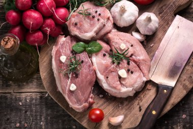 Taze kasap et ürün yelpazesine ahşap masa üzerinde taze biberiye ile süslenmiş kesmek