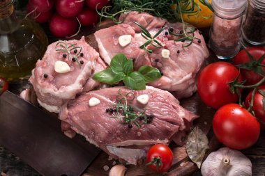 Taze kasap et ürün yelpazesine ahşap masa üzerinde taze biberiye ile süslenmiş kesmek