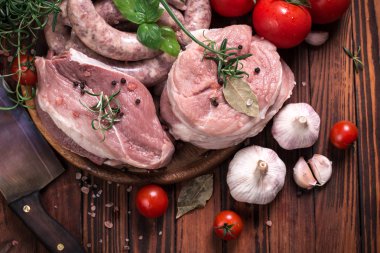 Taze kasap et ürün yelpazesine ahşap masa üzerinde taze biberiye ile süslenmiş kesmek