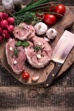 Taze kasap et ürün yelpazesine ahşap masa üzerinde taze biberiye ile süslenmiş kesmek