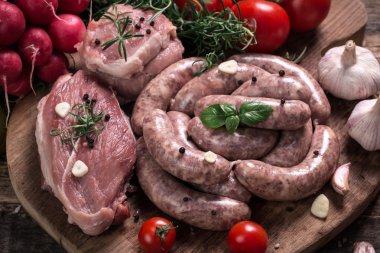 Taze kasap et ürün yelpazesine ahşap masa üzerinde taze biberiye ile süslenmiş kesmek