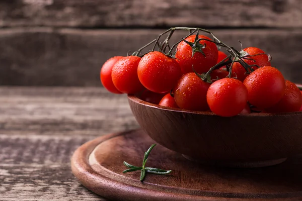 Cherry rajčata na dřevěném pozadí — Stock fotografie