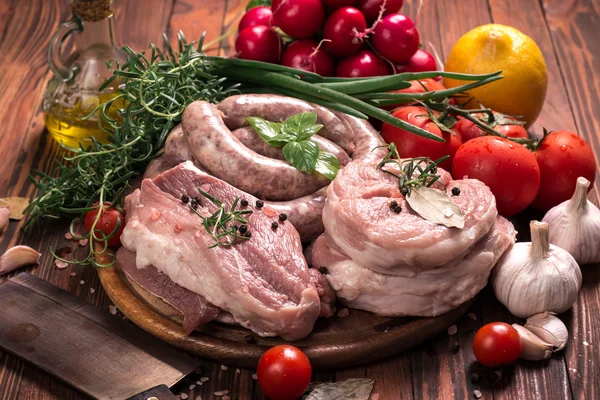 Carnicero fresco corte surtido de carne adornado con romero fresco en mesa de madera — Foto de Stock