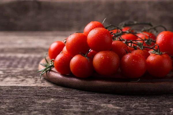 Cherry rajčata na dřevěném pozadí — Stock fotografie