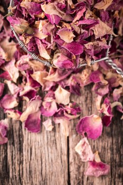 Gül yaprakları ve eski ahşap masa kaşık çiçek kurutulmuş