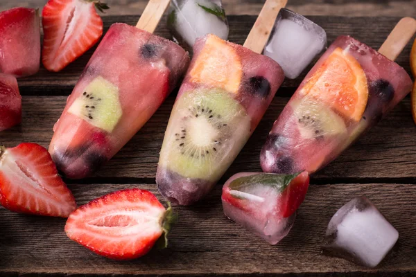 Ghiaccioli integrali di frutta sana con bacche Fragole di kiwi su tavolo vintage in legno — Foto Stock