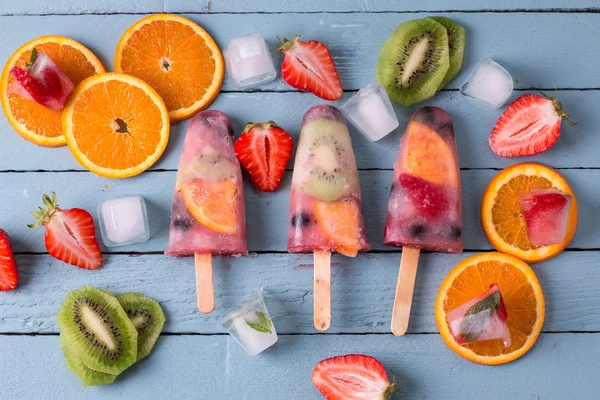 Paletas de frutas enteras saludables con fresas kiwi de bayas en mesa vintage de madera —  Fotos de Stock