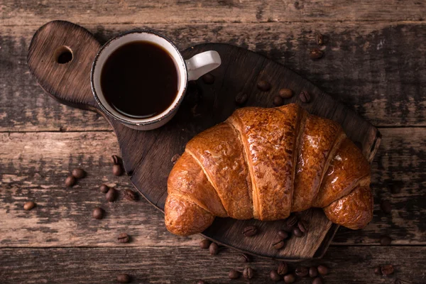 Frukost med kaffe och croissanter på vintage träbord — Stockfoto