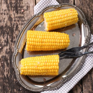 ev yapımı altın mısır mısır koçanı tereyağı ile görünüm ve ahşap masa üzerinde tuz kapatın.