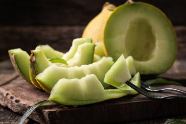 Dilimlenmiş taze kavun ve ahşap masa, sağlıklı gıda nane