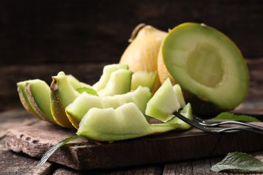 Dilimlenmiş taze kavun ve ahşap masa, sağlıklı gıda nane