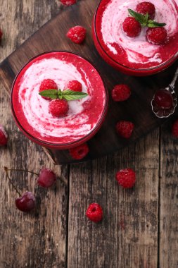 Dondurma ve rustik ahşap zemin üzerine nane ile pembe ahududu güler yüzlü