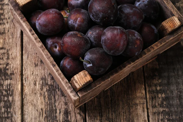 Prunes mûres sur fond vintage en bois — Photo