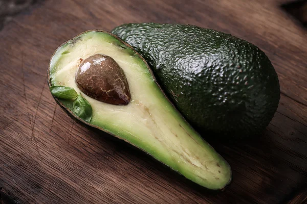 Lebensmittelhintergrund mit frischer Bio-Avocado auf altem Holztisch, Draufsicht, Kopierraum — Stockfoto